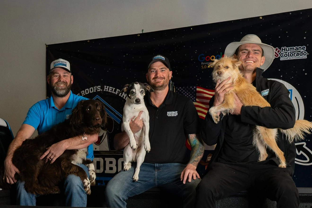 GoodBoy Roofing team members holding dogs